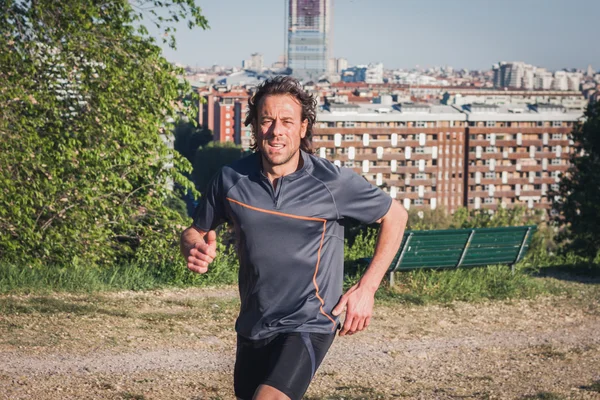 Довгошерстий спортсмен бігає в міському парку — стокове фото
