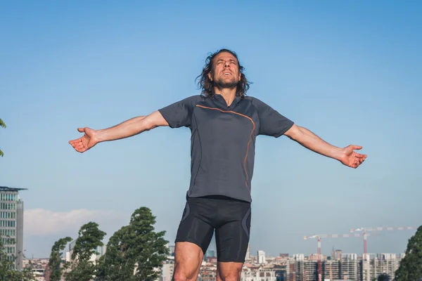Ritratto di un atleta dai capelli lunghi contro il cielo blu — Foto Stock