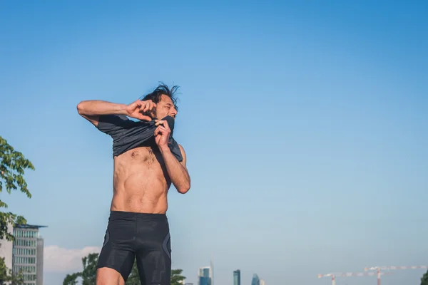 Ritratto di un atleta dai capelli lunghi contro il cielo blu — Foto Stock