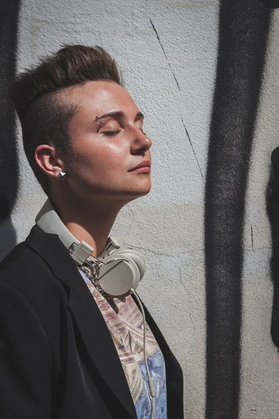 Hübsche Mädchen mit kurzen Haaren posiert gegen eine Wand — Stockfoto