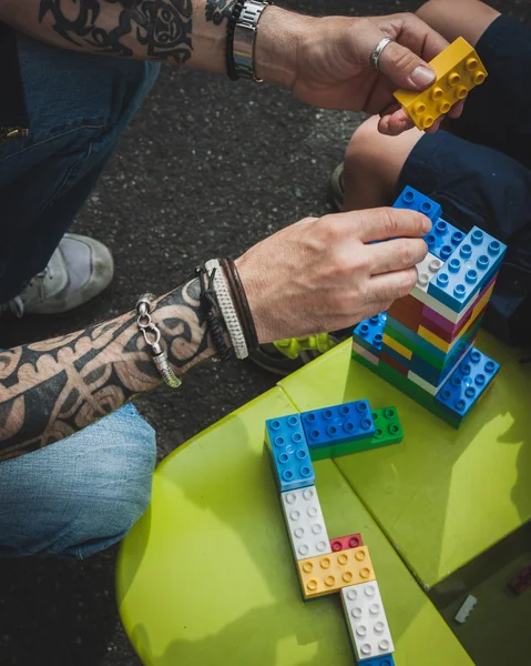 El hombre ayuda a su hijo con ladrillos de Lego en Milán, Italia —  Fotos de Stock