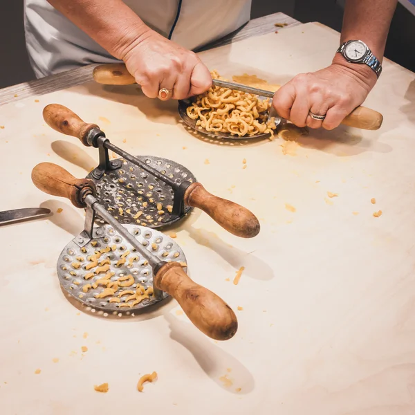 Preparazione di pasta fresca passatelli con attrezzo tradizionale — Foto Stock