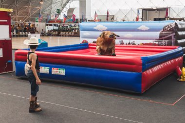 küçük kovboy ve mekanik boğaya at sallanır park olay Milano, İtalya