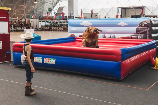 Joven vaquero y toro mecánico en el evento Rocking the Park en Milán, Italia — Foto de Stock