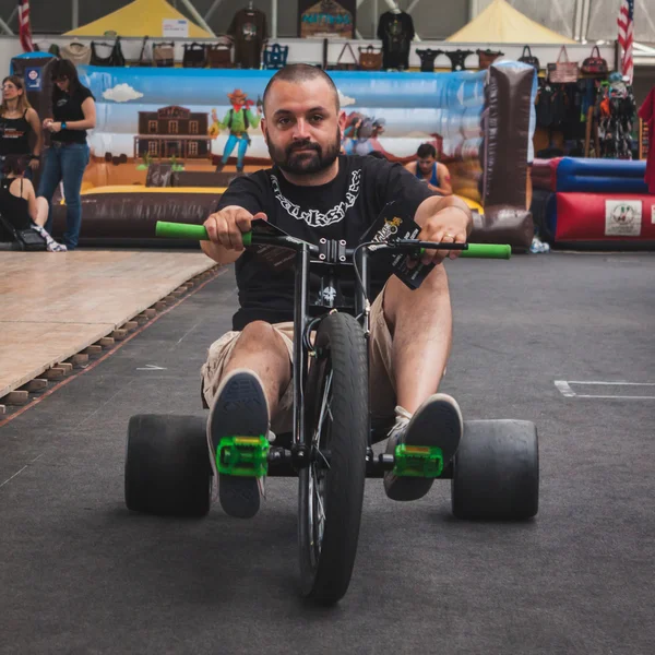 Guy pedalling on tricycle at Rocking the Park event in Milan, Italy — Stock Photo, Image