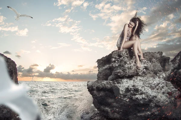 Retrato de mulher sexy sentado na rocha no mar Fotografias De Stock Royalty-Free