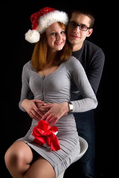 Portrait of sexy couple posing in studio with present — Stock Photo, Image