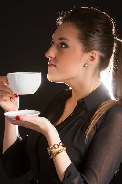 Porträt einer schönen Frau, die mit einer Tasse Kaffee im Studio posiert — Stockfoto