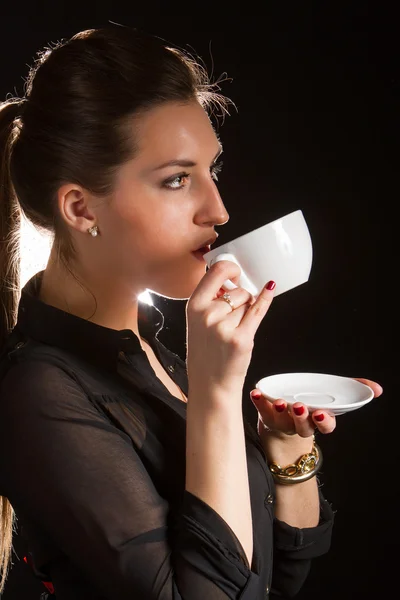 Porträt einer schönen Frau, die mit einer Tasse Kaffee im Studio posiert — Stockfoto