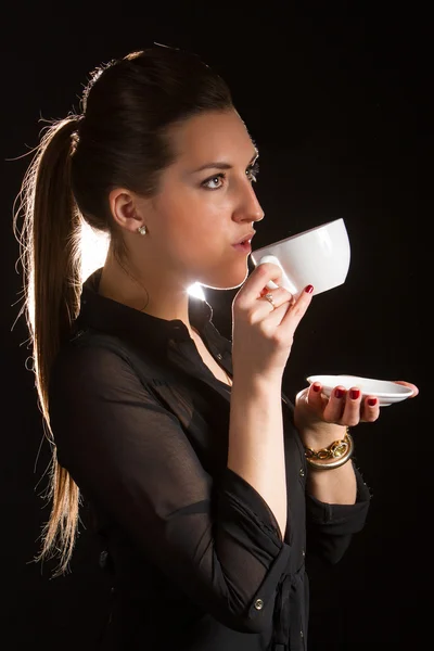 Porträt einer schönen Frau, die mit einer Tasse Kaffee im Studio posiert — Stockfoto