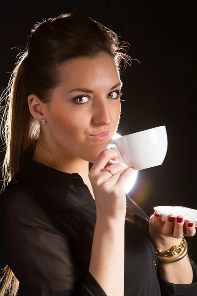 Porträt einer schönen Frau, die mit einer Tasse Kaffee im Studio posiert — Stockfoto