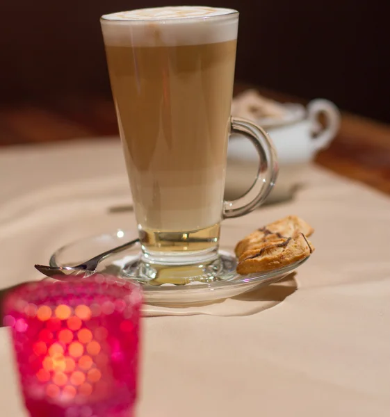 Imagen de capuchino caliente en vidrio sobre mesa con galletas — Foto de Stock