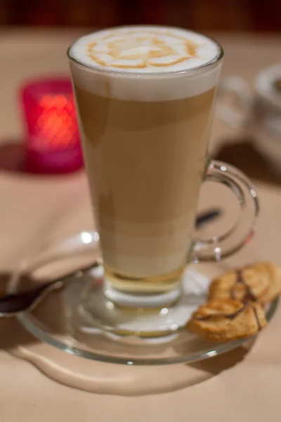 Imagen de capuchino caliente en vidrio sobre mesa con galletas — Foto de Stock