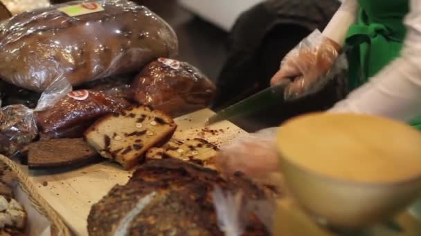 Mujer cortar el sabroso pan en la mesa con cuchillo — Vídeo de stock