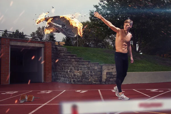 Imagen del hombre muscular desnudo lanzando su ropa deportiva en llamas —  Fotos de Stock