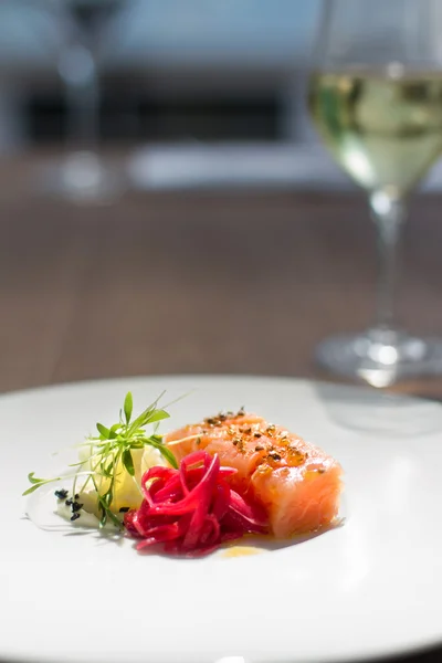 Bild von schmackhaftem Lachs auf Teller mit weißem Weinstock — Stockfoto
