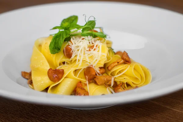 Bilden av pasta med kantareller serveras i vit skål — Stockfoto