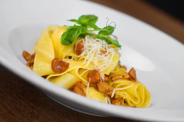 Bilden av pasta med kantareller serveras i vit skål — Stockfoto