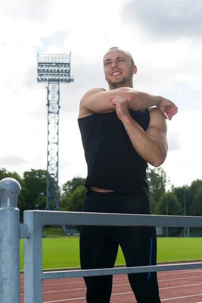 Imagen del hombre muscular estirándose en el estadio — Foto de Stock