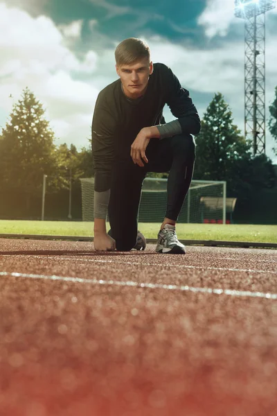 Portrait of sexy sportsman posing on stadium in sportswear — Stock Photo, Image