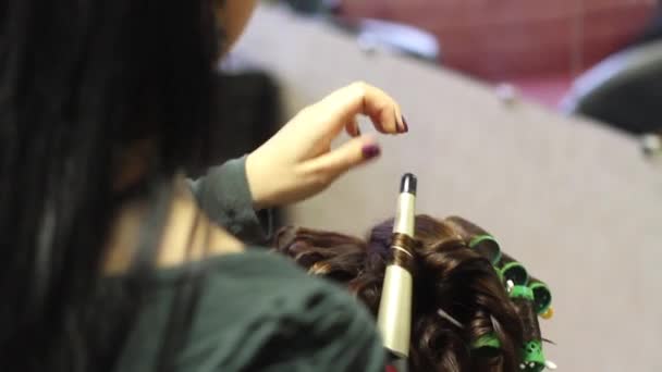 Видеозапись парикмахера, делающего прическу на женщинах — стоковое видео