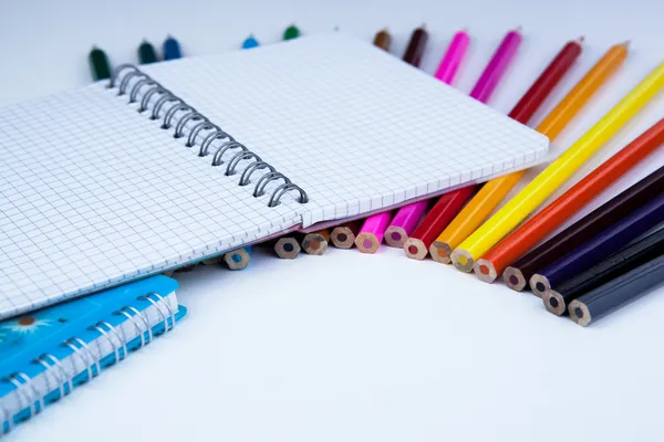 Uma pilha de lápis coloridos com notebook — Fotografia de Stock