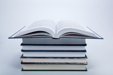 Kitap yığınının üzerinde açık bir kitap