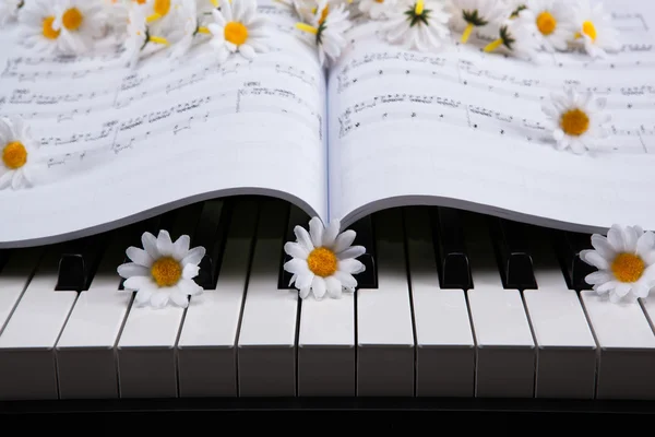 Piano toetsen en muzikale boek en bloem — Stockfoto