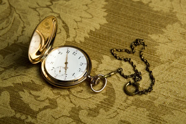 Gouden zakhorloge op gouden doek — Stockfoto