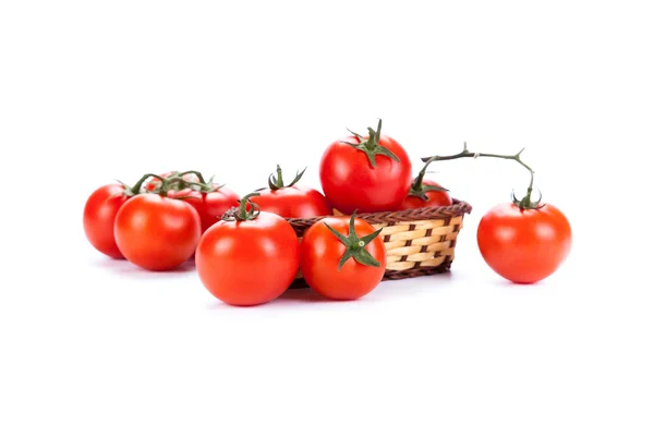 Rode tomaten in een klein mandje op een witte achtergrond — Stockfoto