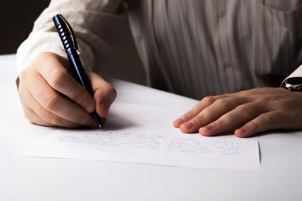 Hombre está escribiendo en una hoja de papel — Foto de Stock