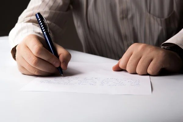 Homem está escrevendo em uma folha de papel — Fotografia de Stock