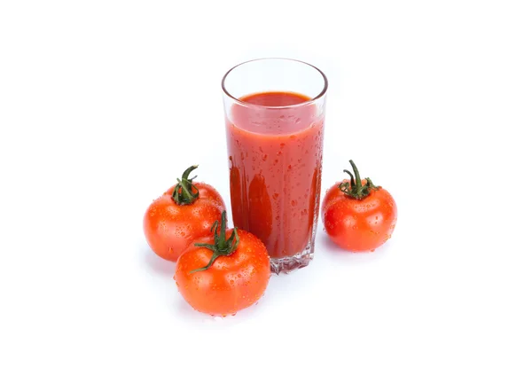 Rode tomaten en glas tomatensap op een witte achtergrond — Stockfoto