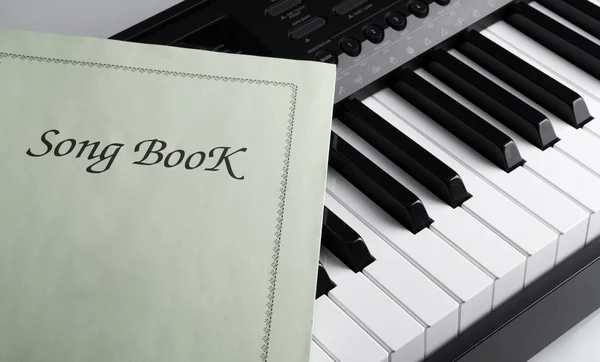 Piano keys and song book — Stock Photo, Image