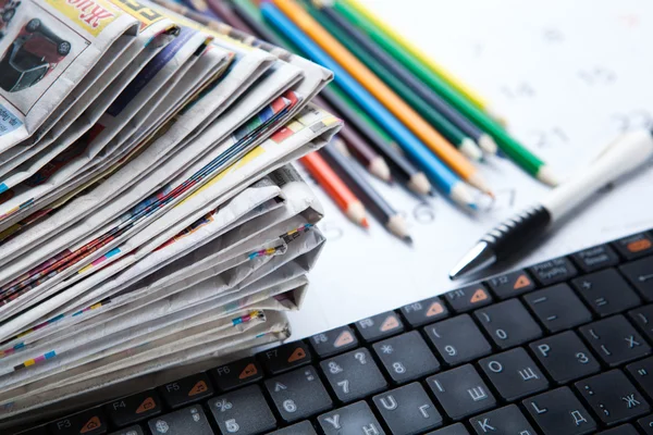 Zeitungsstapel und Tastatur in Großaufnahme — Stockfoto