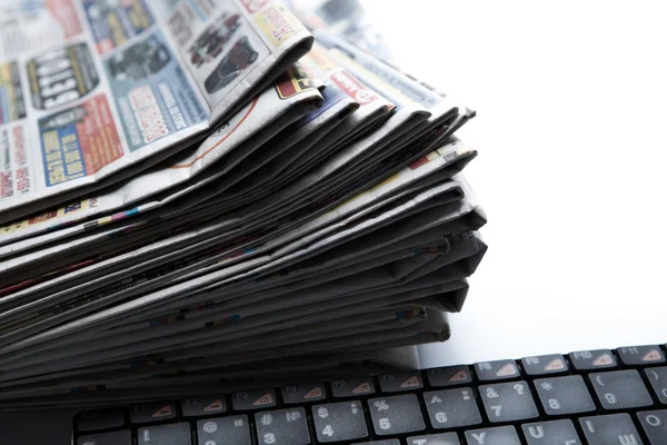 Stack of newspapers and keyboard close-up Stock Picture