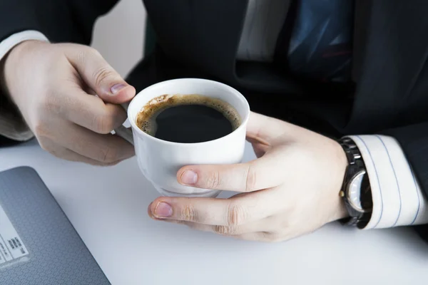 Homem segurando a xícara de café no local de trabalho — Fotografia de Stock