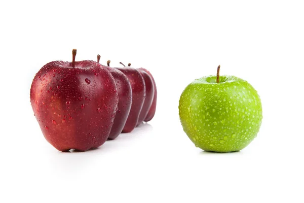 Maroon äpplen uppradade i en rad och green apple närbild — Stockfoto