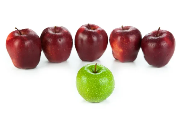 Maroon apples lined up in a row and green apple closeup — Stock Photo, Image