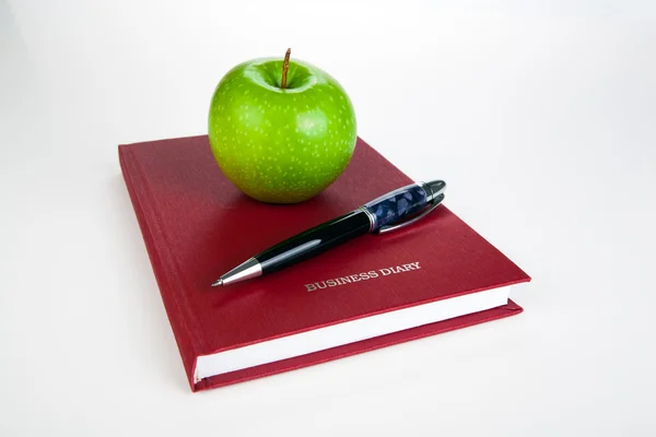 Kalem ve yeşil elma ile iş günlüğü — Stok fotoğraf