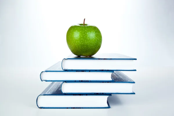 Hromada knih se zeleným jablkem — Stock fotografie
