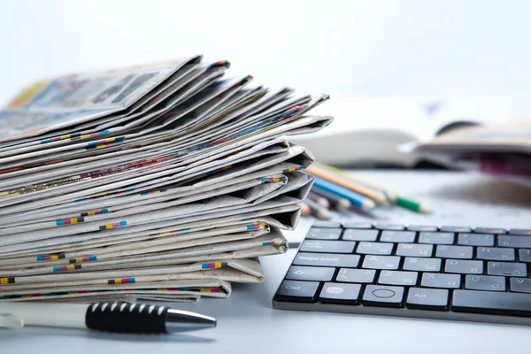 Stack of newspapers and keyboard close-up — Stock Photo, Image