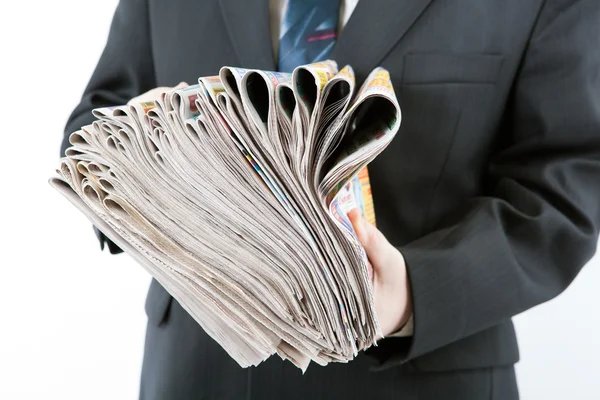 Man's hands holding a stack of newspapers — Stock Photo, Image