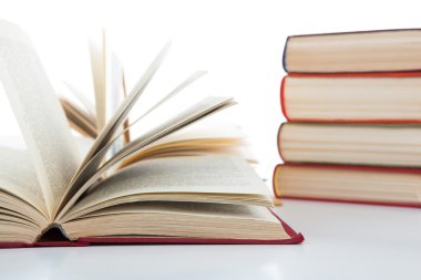 Açık kitap ve kitap beyaz üzerine yığını