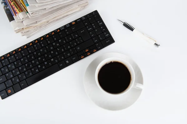 Pila de periódicos y teclado con taza de café primer plano —  Fotos de Stock