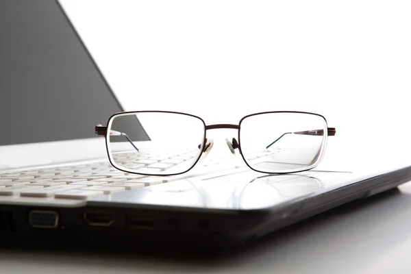 Bril op een laptop toetsenbord — Stockfoto
