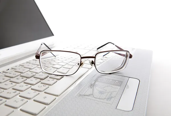 ノート パソコンのキーボード上の目のメガネ — ストック写真