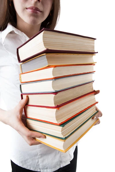 Jovem segurando uma pilha de livros — Fotografia de Stock