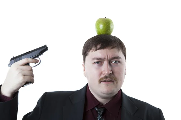 Mann zielt auf den Apfel am Kopf — Stockfoto