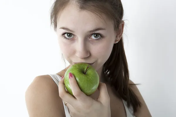 Ung flicka med äpple på grå Stockfoto